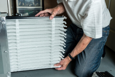Senior man installing a new air filter