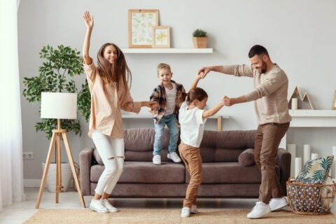 Parents dancing with kids in living room in Utah County home