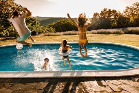 Family jumping together into swimming pool