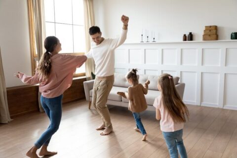 Family of 4 dancing in living room