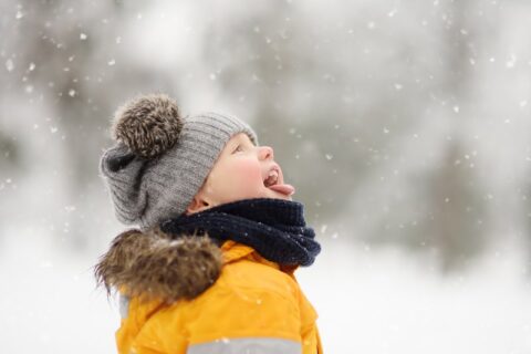 Kid catches snow flurries on tongue outside