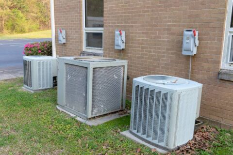 Air conditioner compressors outside brick building