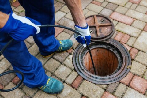 sewer worker cleaning a clogged drain with hydro jetting